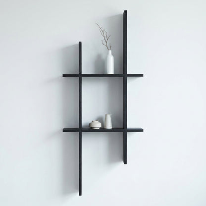 Prateleira de parede Mostar em pinho preto montada numa parede clara, com objectos decorativos