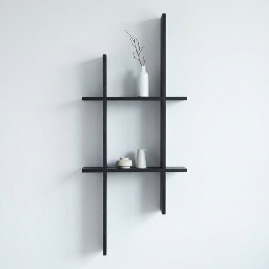Prateleira de parede Mostar em pinho preto montada numa parede clara, com objectos decorativos