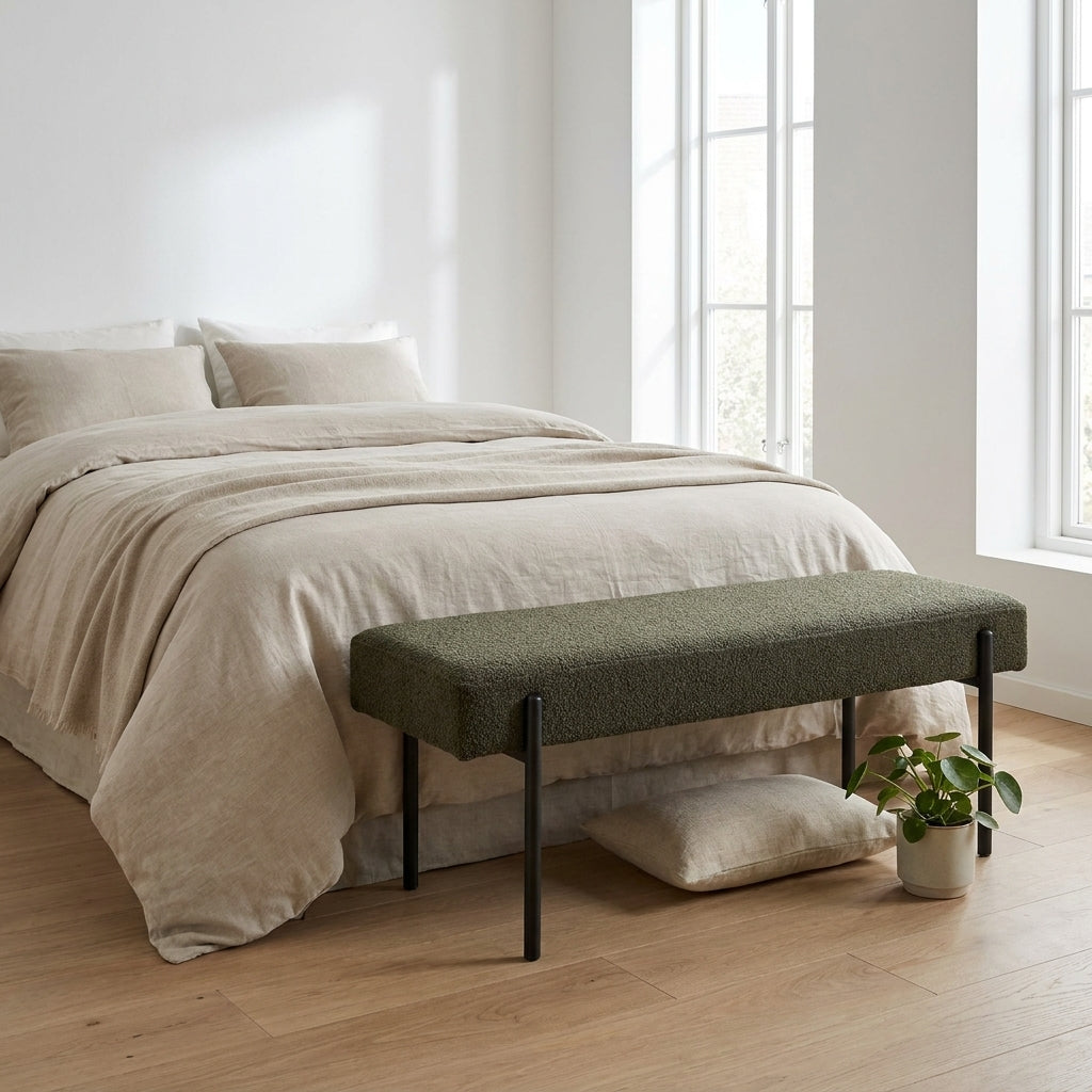 Banco Swindon em bouclé verde-escuro aos pés de uma cama — ambiente