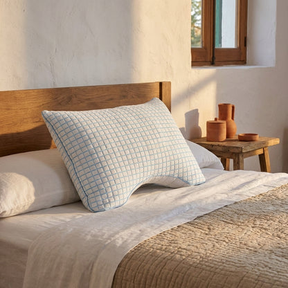 Almofada de dormir com recorte, fresca, 45 × 65 cm, encostada à cabeceira num quarto mediterrânico