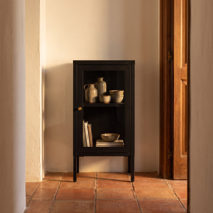 Armário Dalby preto com uma porta de vidro num corredor