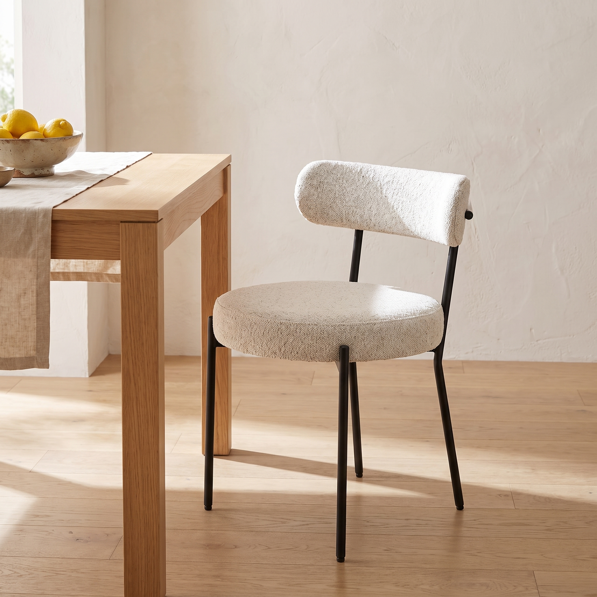 Cadeira de jantar Badalona em bouclé branco junto a uma mesa de carvalho