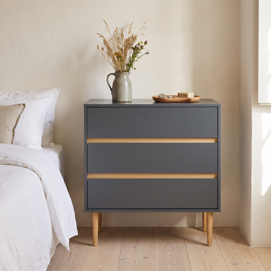 Cómoda Bisley com três gavetas em cinzento-escuro num quarto
