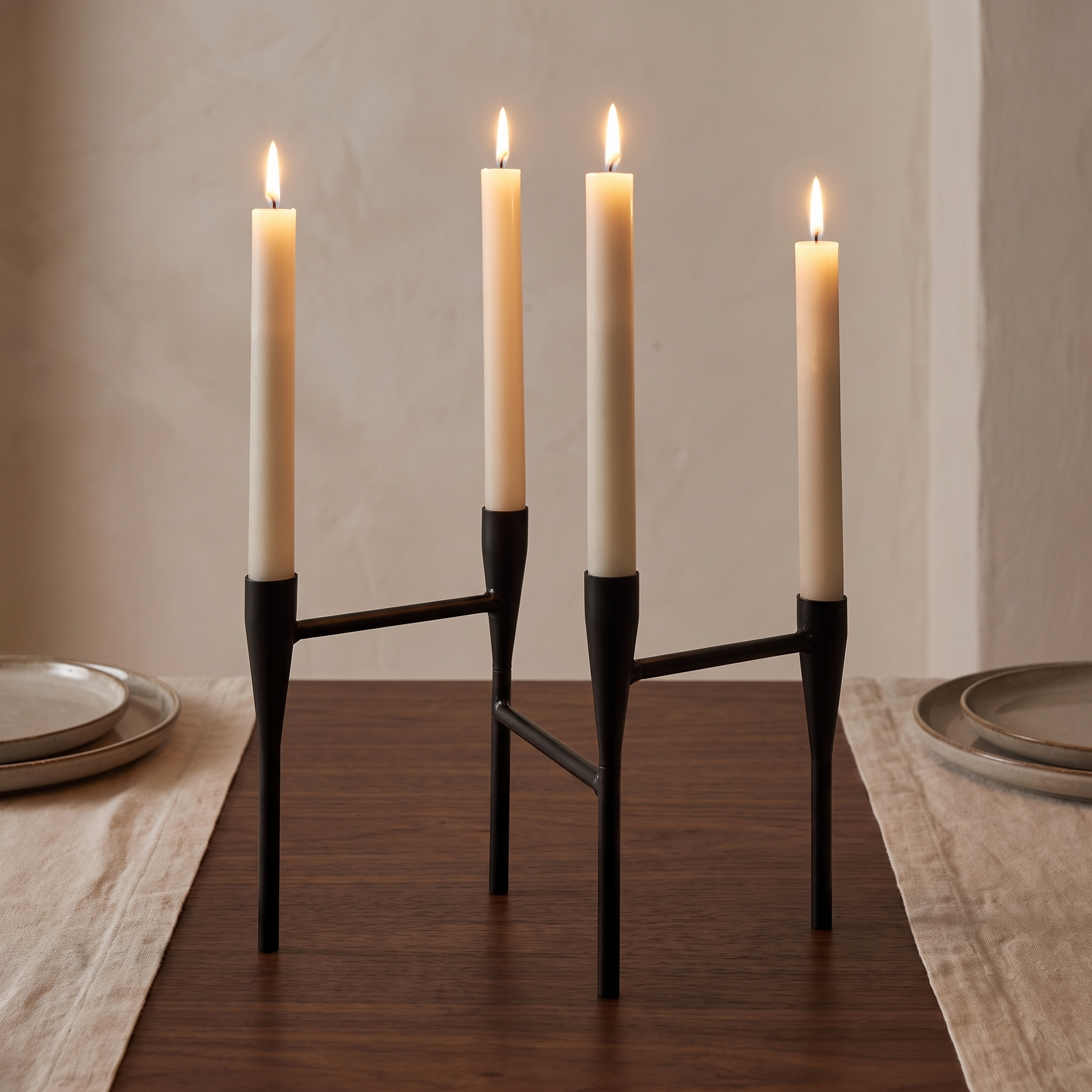 Porta-velas em aço preto com velas acesas ao centro de uma mesa