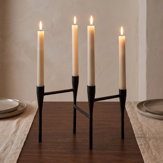 Porta-velas em aço preto com velas acesas ao centro de uma mesa
