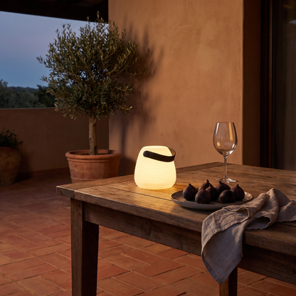 Candeeiro LED Derry recarregável de 12 cm numa mesa de terraço