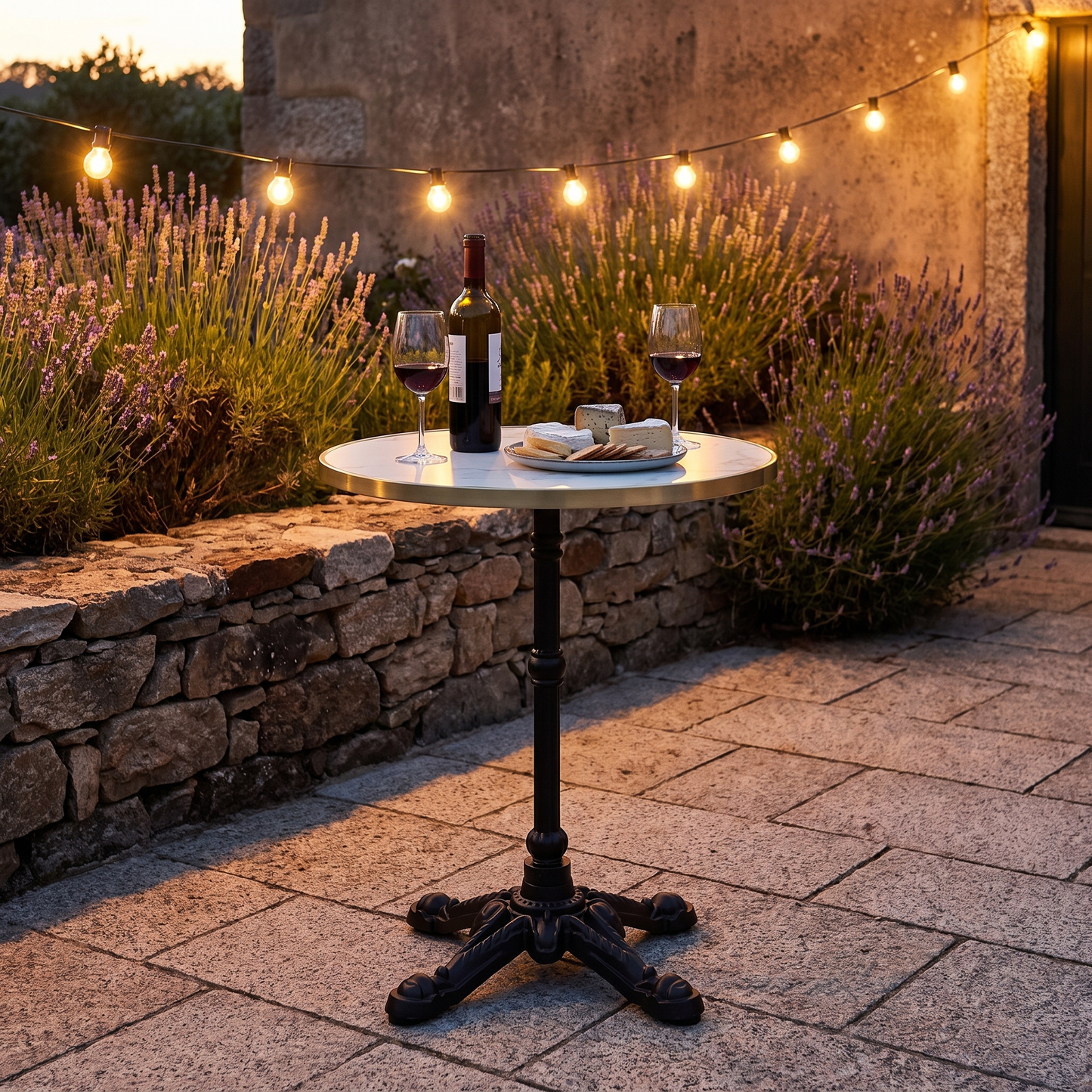 Mesa bistrô com tampo em mármore branco e pés em ferro fundido num jardim