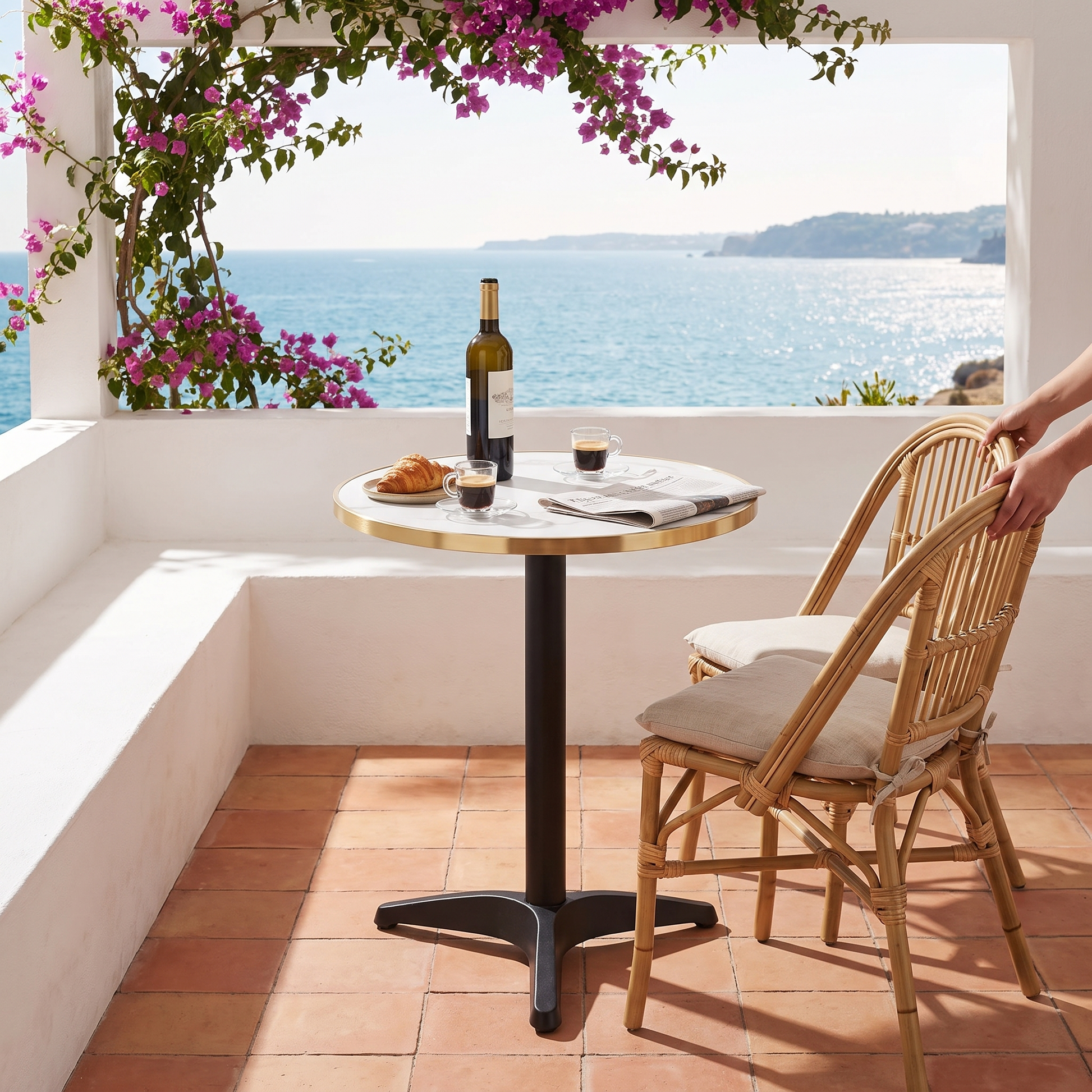 Mesa bistrô com tampo em mármore branco e bordo dourado num terraço