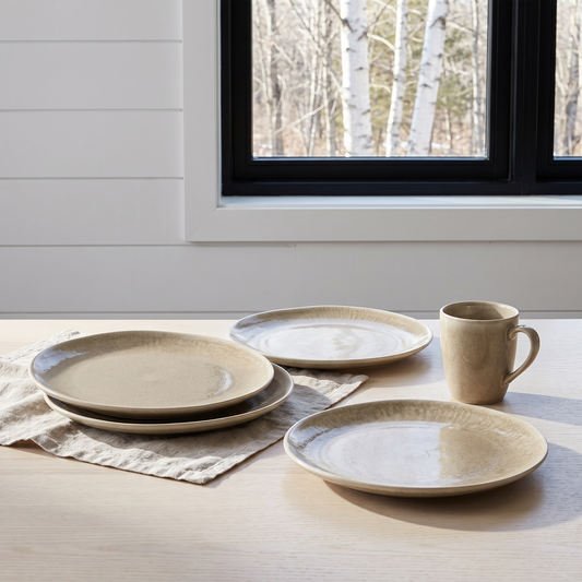 Conjunto de quatro pratos de jantar Viola em grés bege numa mesa escandinava