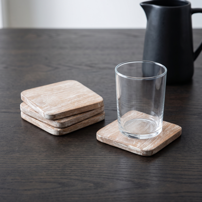 Quatro porta-copos quadrados em teca rustica branco lavado numa mesa de carvalho fumado