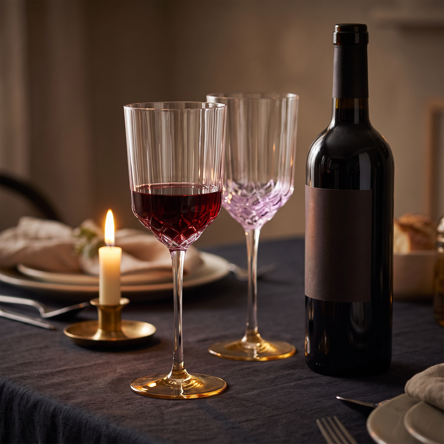 Tacas de vinho Pink Blush em vidro transparente com relevo lilas e pe dourado, numa mesa posta a luz de vela