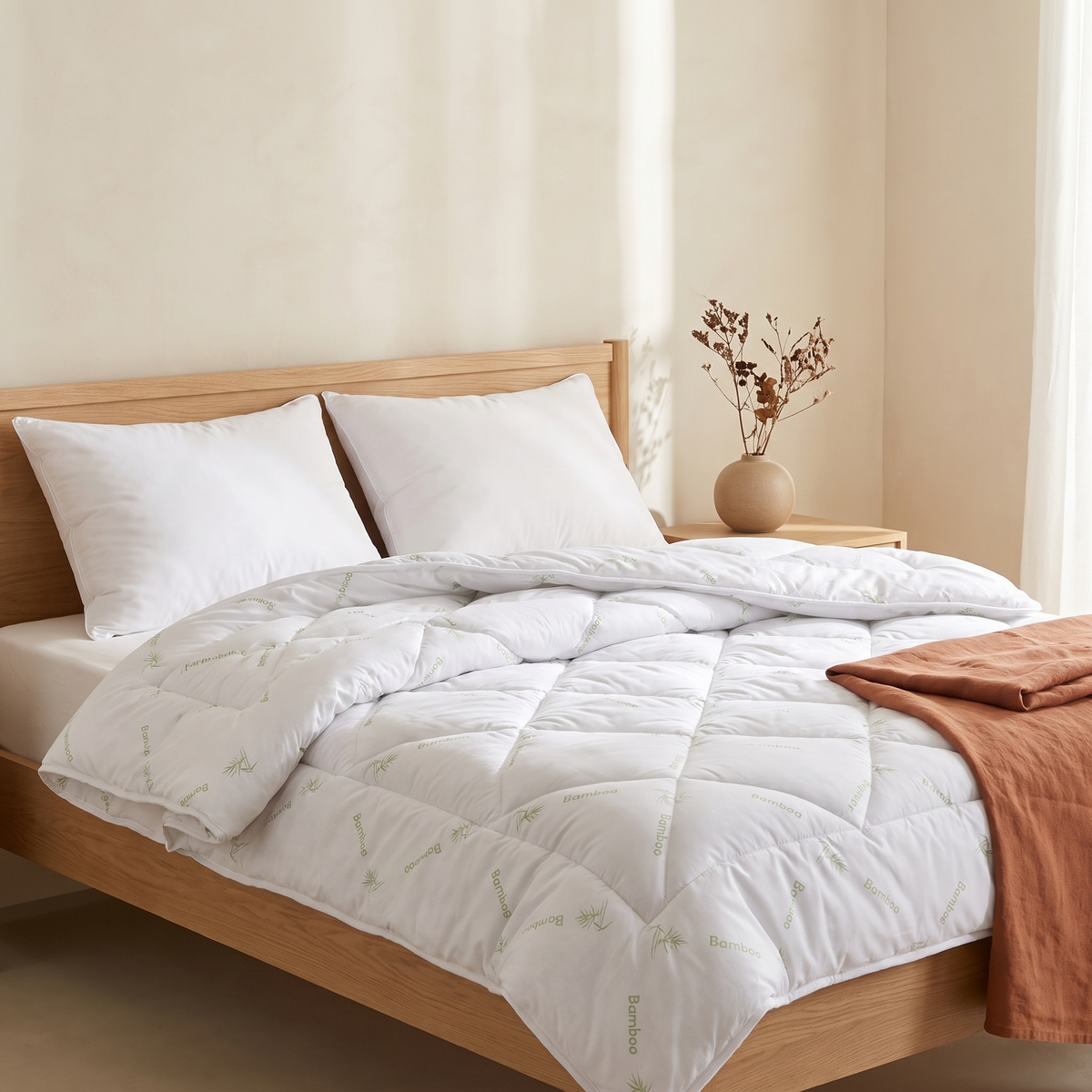 Edredão Bali toque de bambu branco numa cama de casal, quarto quente em tons creme e terracota