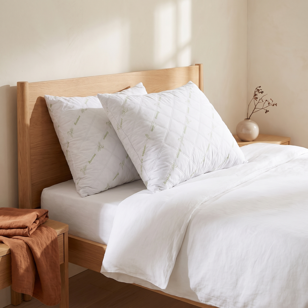 Pack de 2 almofadas de dormir toque de bambu numa cama de casal, quarto quente em tons creme e terracota
