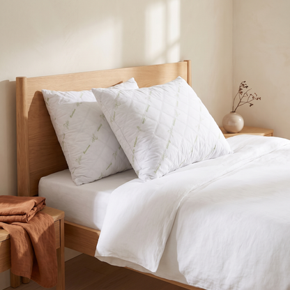 Pack de 2 almofadas de dormir toque de bambu numa cama de casal, quarto quente em tons creme e terracota