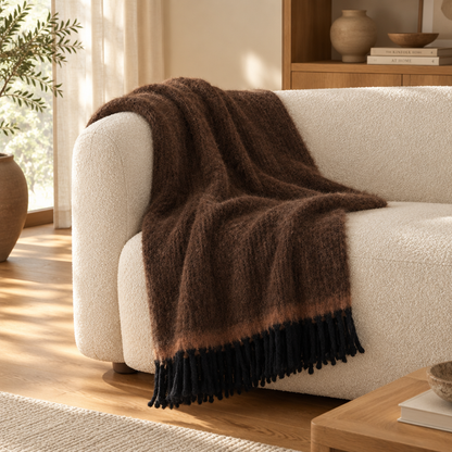 Manta Carmel castanha sobre um sofá de bouclé — ambiente